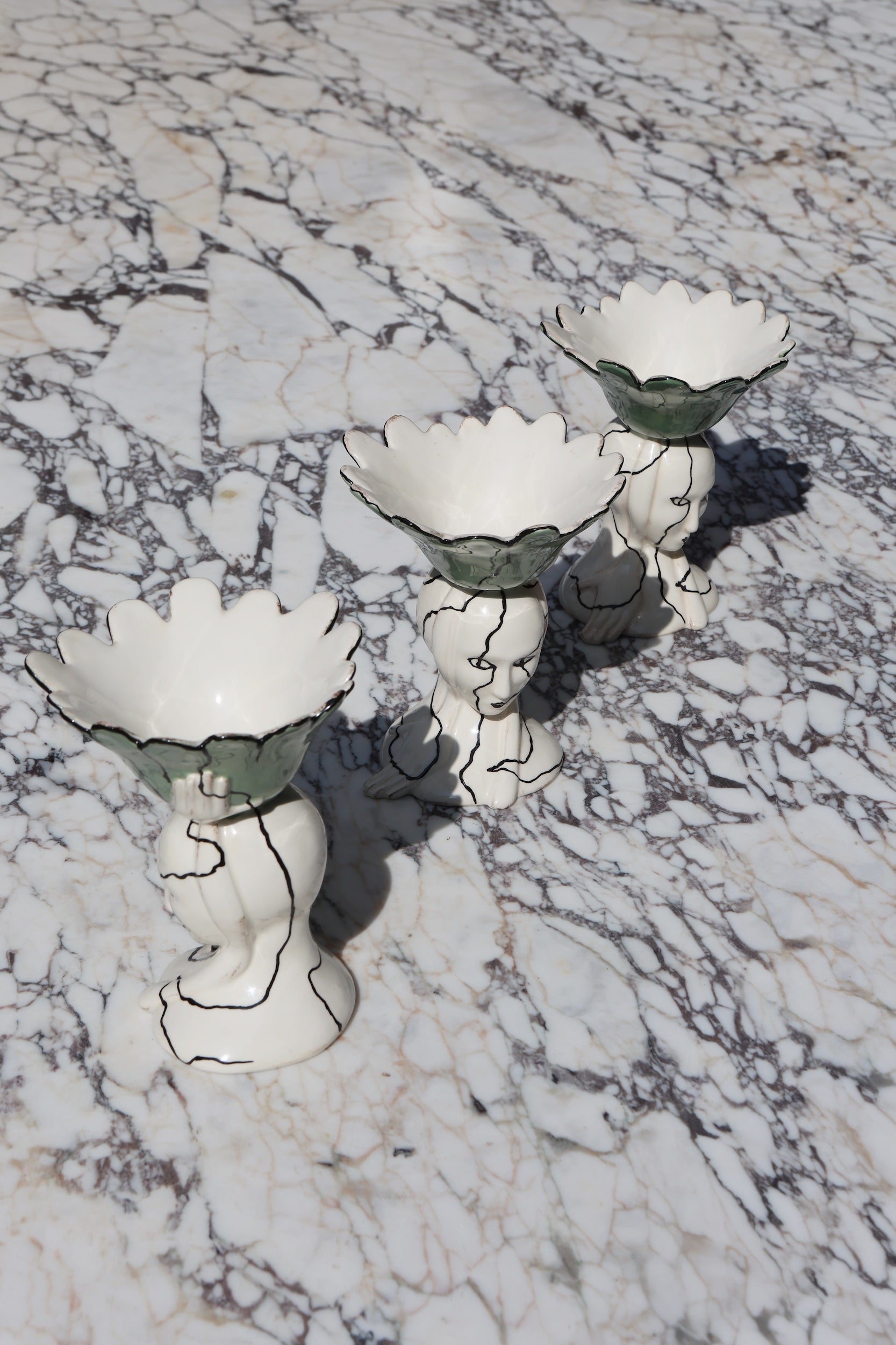 Three hand made and hand glazed ceramic bowls in white and green with decorative line work