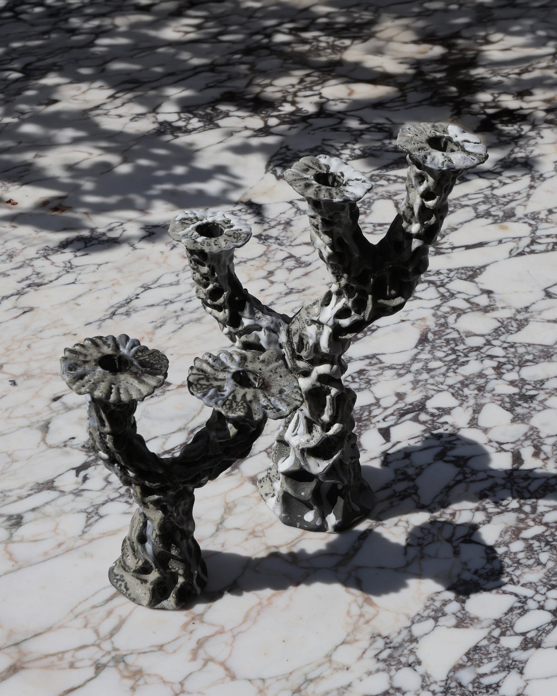 Hand made decorative ceramic candle holder with three pedestals. Surrealist modern design with a textured gray glaze that looks like dripping wax. 