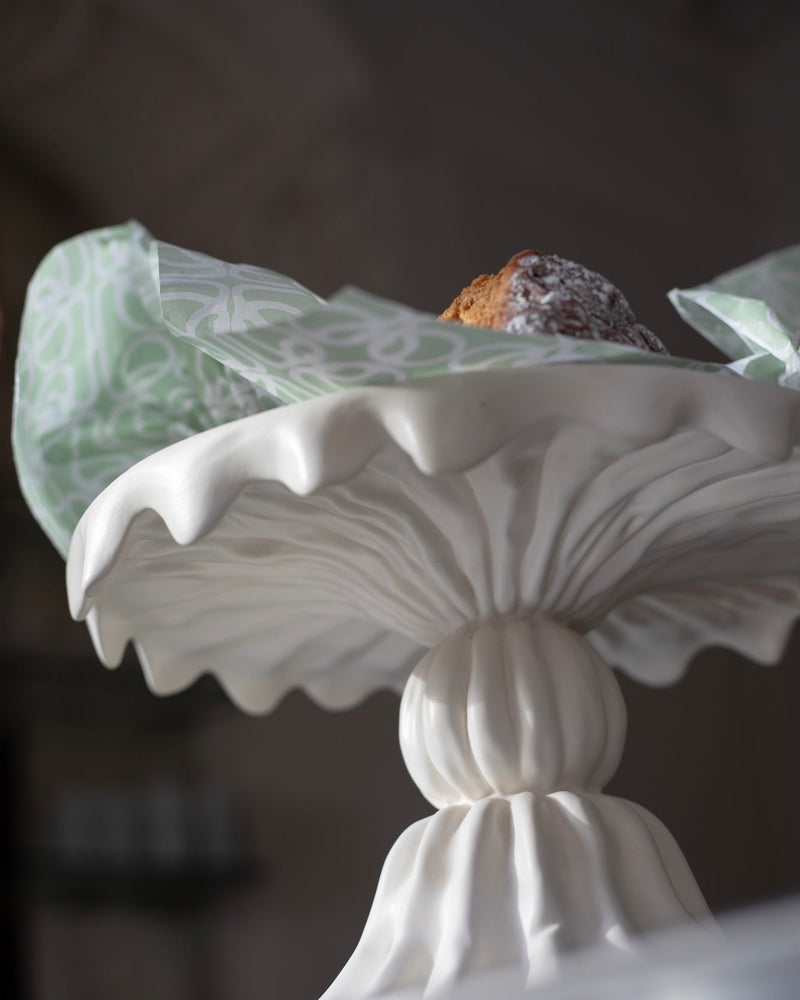 White decorative handmade ceramic cake stand styled with a cake