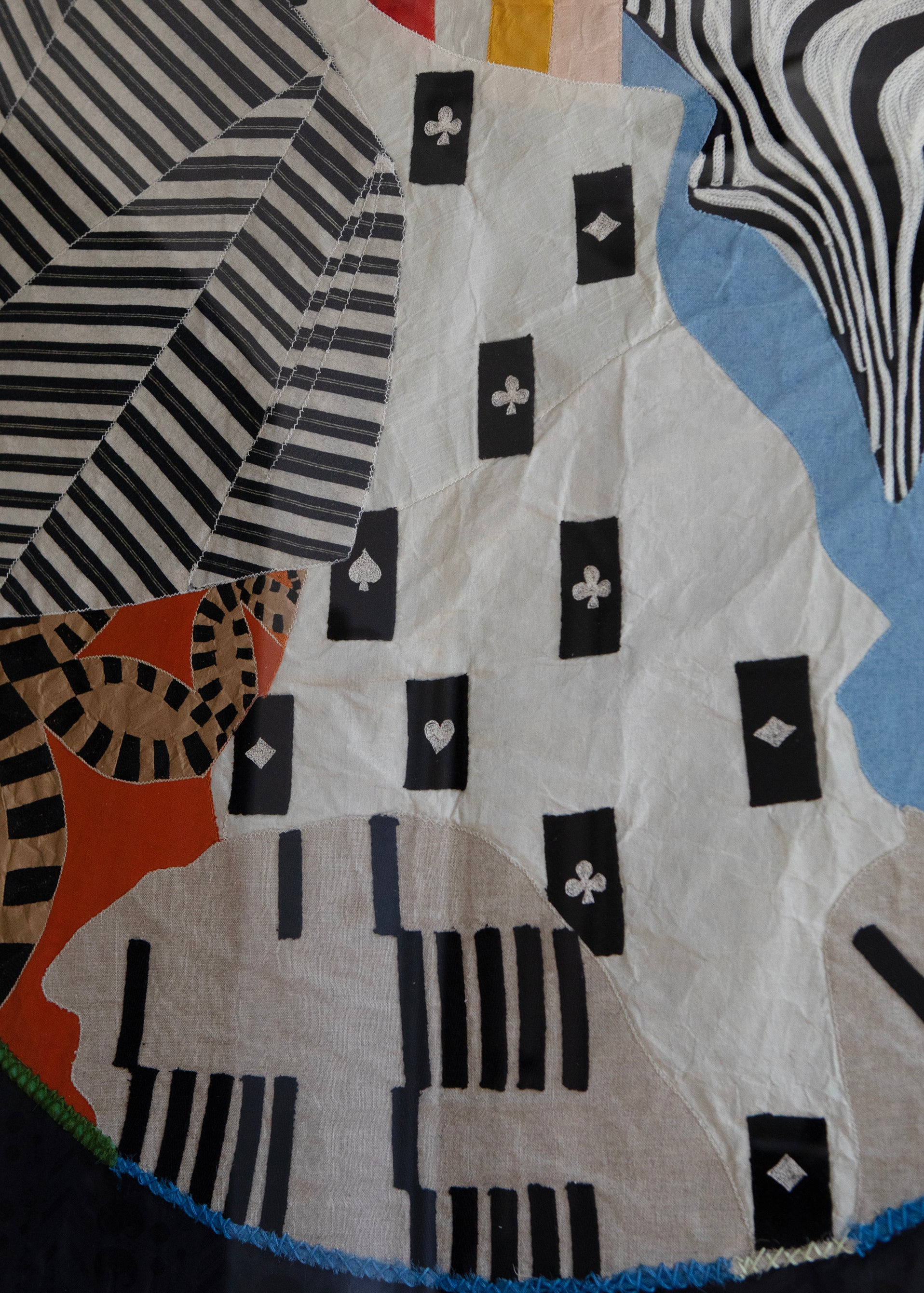 Detail of hand made decorative tapestry with an abstract and surrealist design motif that suggests a globe. Hand crafted and hand embroidered from antique silks. Made in India, artisanal home decor. Modern tapestry design. 