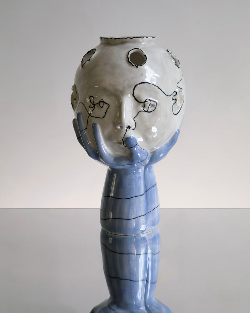 Head in Hands Wish Vase by House of Quentin Jones — a sculptural ceramic vase with hands cradling a face, handmade earthenware. Blue and white surrealist style vase.
